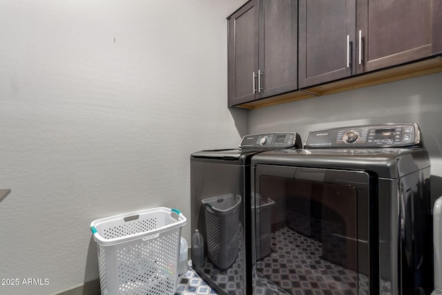 laundry area with cabinet space, a textured wall, and separate washer and dryer