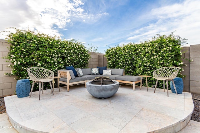 view of patio with a fenced backyard and an outdoor living space with a fire pit