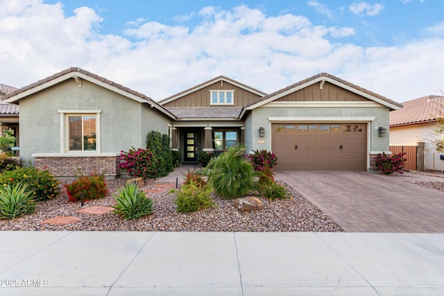 view of front of home with fence, a tiled roof, a garage, stucco siding, and driveway