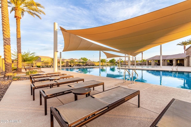 community pool with fence and a patio area