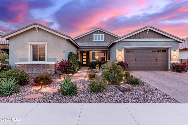 view of front of property featuring driveway, stucco siding, a tile roof, and a garage
