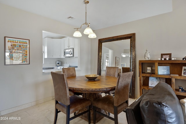 tiled dining area with an inviting chandelier