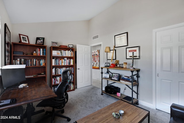 carpeted home office featuring lofted ceiling