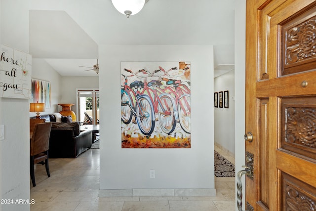 interior space with vaulted ceiling, ceiling fan, and light tile floors