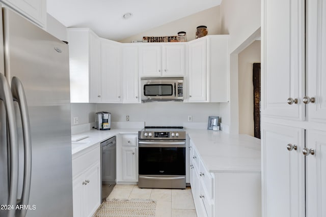 kitchen featuring appliances with stainless steel finishes, white cabinets, light tile floors, and light stone countertops