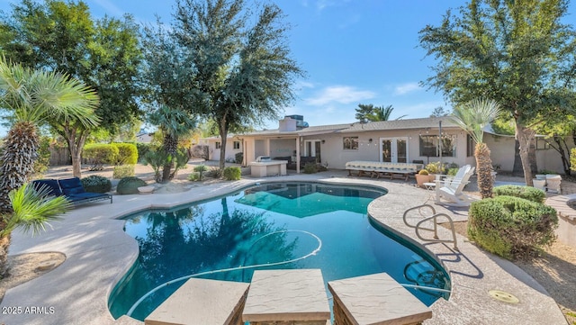 view of swimming pool featuring a patio area and french doors