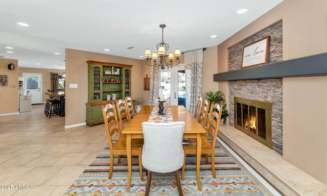 dining space featuring a fireplace and a notable chandelier