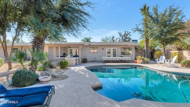 view of pool featuring french doors, an outdoor kitchen, and a patio area