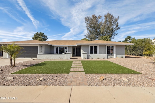 ranch-style house with a garage and a front lawn