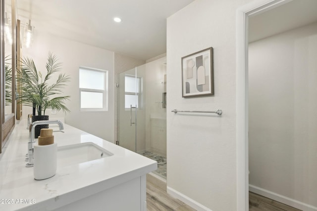 bathroom with hardwood / wood-style flooring, vanity, and an enclosed shower