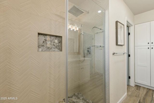 bathroom with wood-type flooring and a shower with door