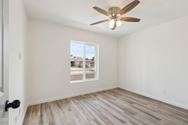 empty room with ceiling fan and light hardwood / wood-style floors