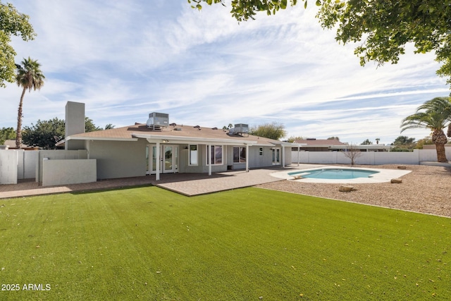 back of property with a fenced in pool, a yard, central AC, and a patio area