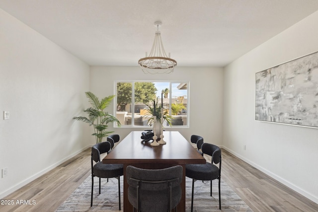 dining area with hardwood / wood-style floors and a notable chandelier