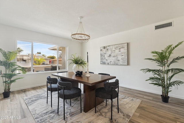 dining room featuring hardwood / wood-style floors and a notable chandelier