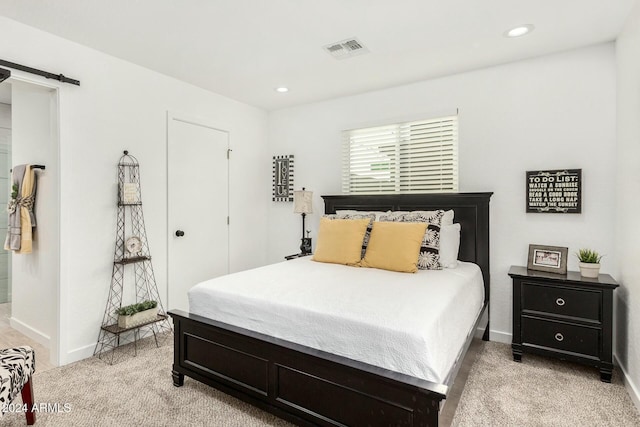 carpeted bedroom with a barn door