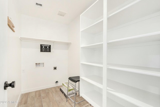 clothes washing area with hookup for a washing machine, hookup for an electric dryer, and hardwood / wood-style flooring