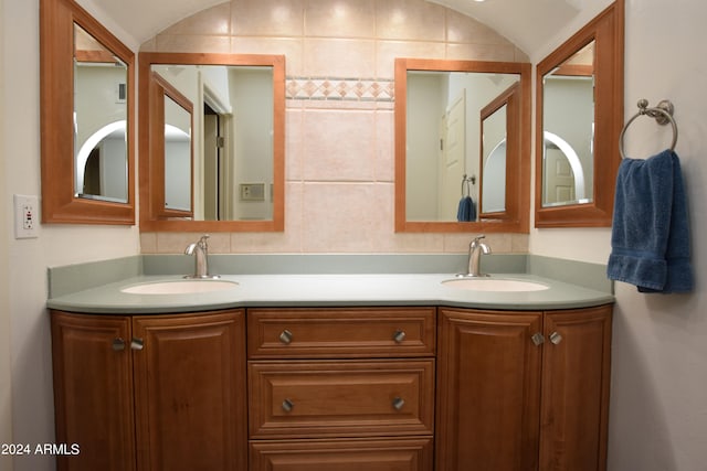 bathroom with lofted ceiling and double sink vanity