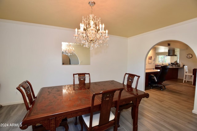 dining room featuring a notable chandelier, hardwood / wood-style flooring, and ornamental molding