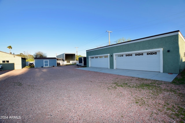 ranch-style house with a garage and a shed