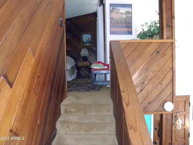 staircase featuring wood walls