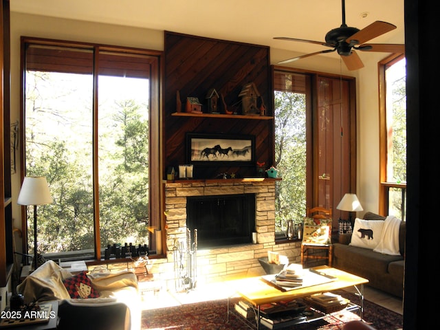 living room with ceiling fan, a healthy amount of sunlight, and a fireplace