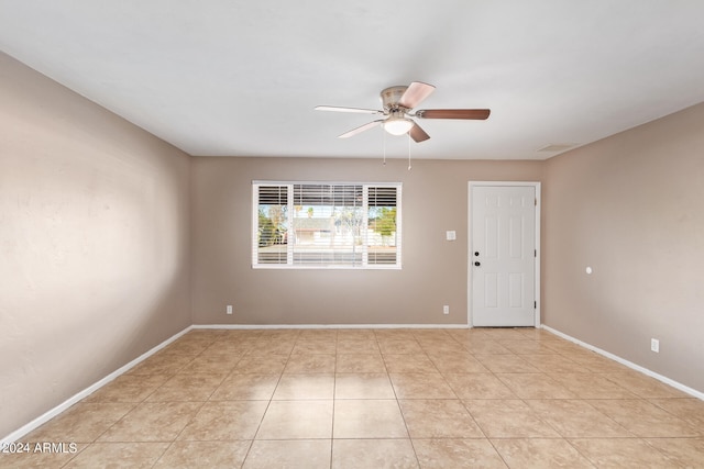 tiled empty room featuring ceiling fan