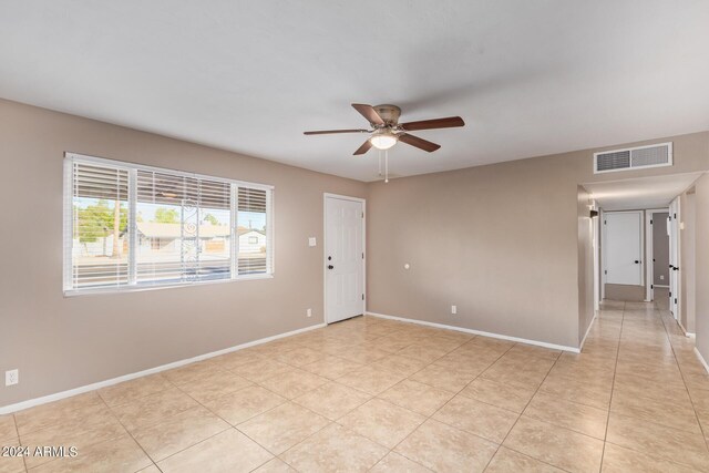 tiled empty room featuring ceiling fan