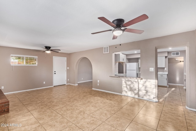 unfurnished living room with ceiling fan and light tile patterned flooring