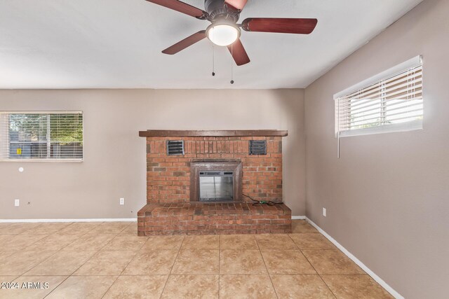 unfurnished living room featuring ceiling fan, tile patterned flooring, and a fireplace