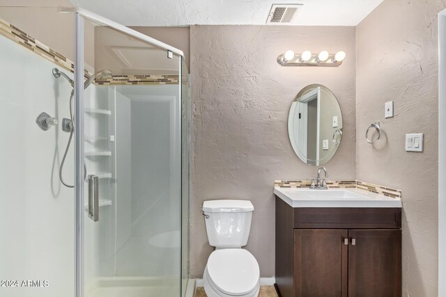 bathroom with an enclosed shower, toilet, and vanity