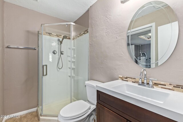 bathroom with tile patterned flooring, vanity, walk in shower, and toilet