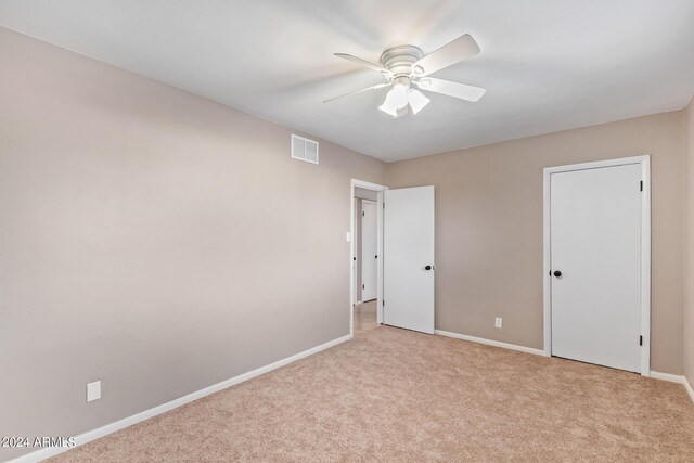 carpeted empty room featuring ceiling fan