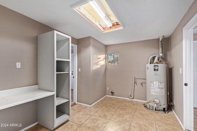 washroom featuring gas water heater and light tile patterned floors