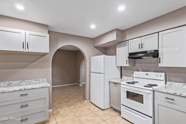 kitchen featuring light stone counters, white cabinetry, light tile patterned flooring, and white appliances