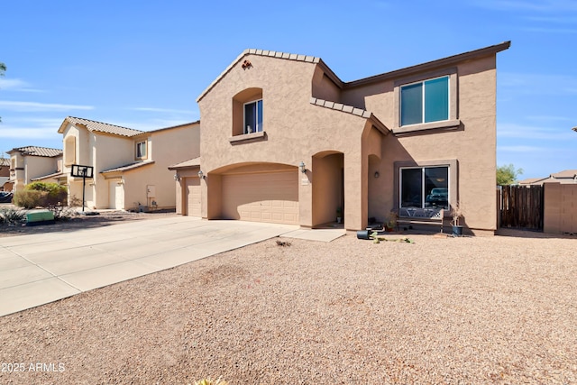 mediterranean / spanish home with concrete driveway, an attached garage, fence, and stucco siding