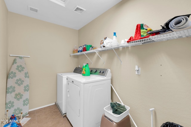 clothes washing area featuring laundry area, light tile patterned flooring, visible vents, and independent washer and dryer