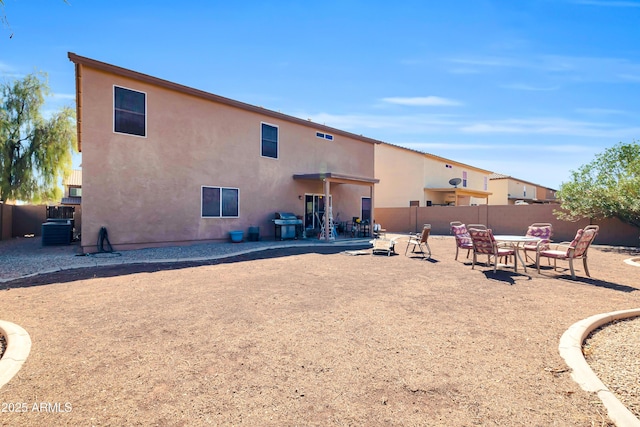 rear view of property featuring a patio area, stucco siding, cooling unit, and fence