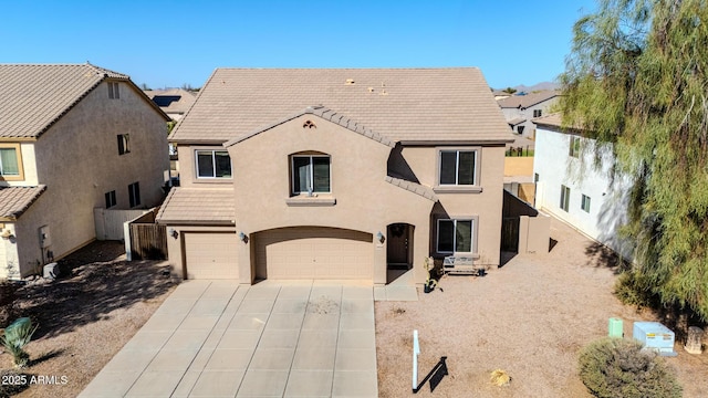 view of front facade featuring stucco siding, fence, concrete driveway, and a tiled roof