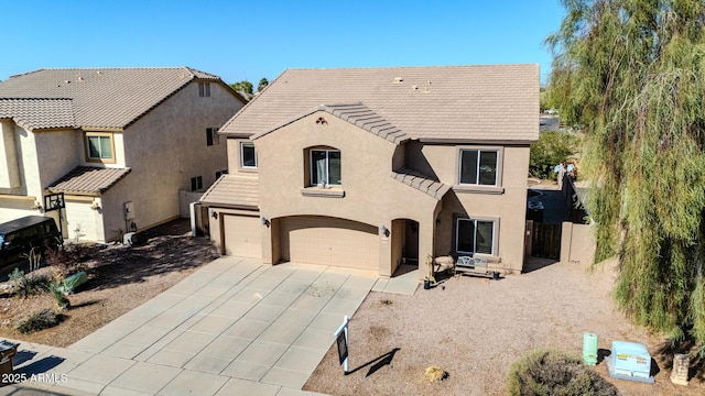 view of front of house featuring stucco siding, a tile roof, fence, concrete driveway, and an attached garage