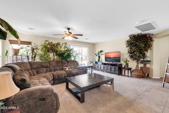 living area with visible vents, light colored carpet, and a ceiling fan