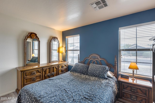 carpeted bedroom featuring visible vents and baseboards