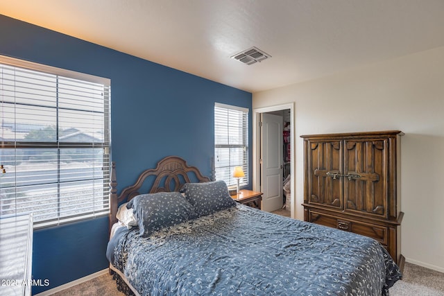 carpeted bedroom featuring baseboards and visible vents