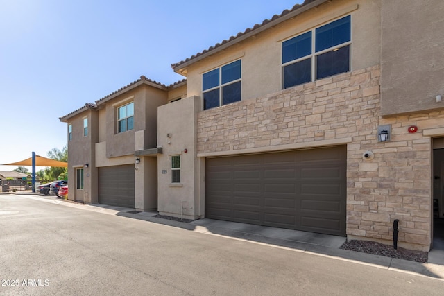 754 E Harper St Unit 102, Gilbert, AZ 85297 - view of front of house featuring stone siding, a garage, stucco siding, and a tile roof
