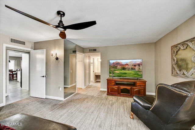 carpeted living room featuring visible vents, a ceiling fan, and baseboards