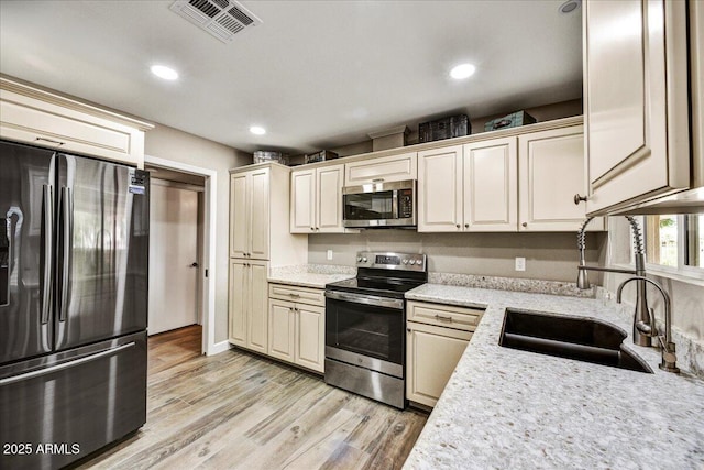 kitchen with visible vents, recessed lighting, a sink, light wood-style flooring, and stainless steel appliances