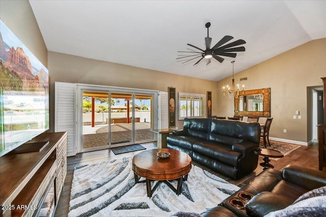 living room featuring ceiling fan with notable chandelier, wood finished floors, vaulted ceiling, and a healthy amount of sunlight