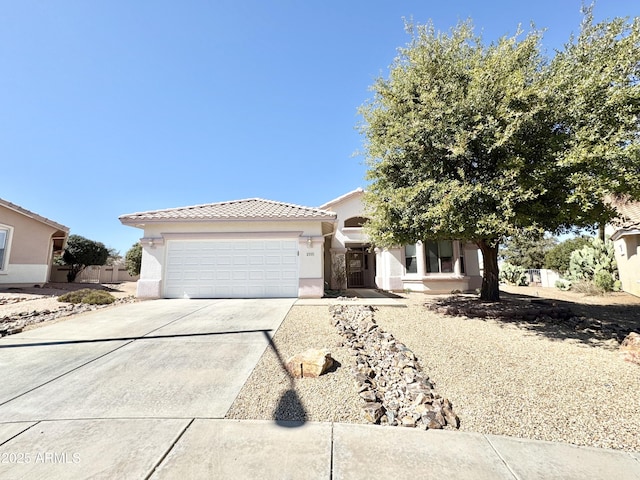 view of front facade featuring a tile roof, a garage, driveway, and stucco siding