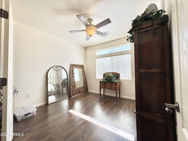 unfurnished room with ceiling fan, baseboards, a textured ceiling, and wood finished floors