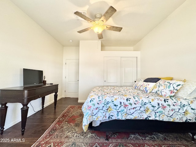 bedroom featuring a closet, baseboards, a ceiling fan, and dark wood-style flooring